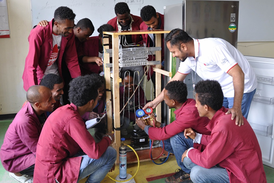 Young and eager Ethiopian trainees learning how to repair appliances under the teacher's guidance