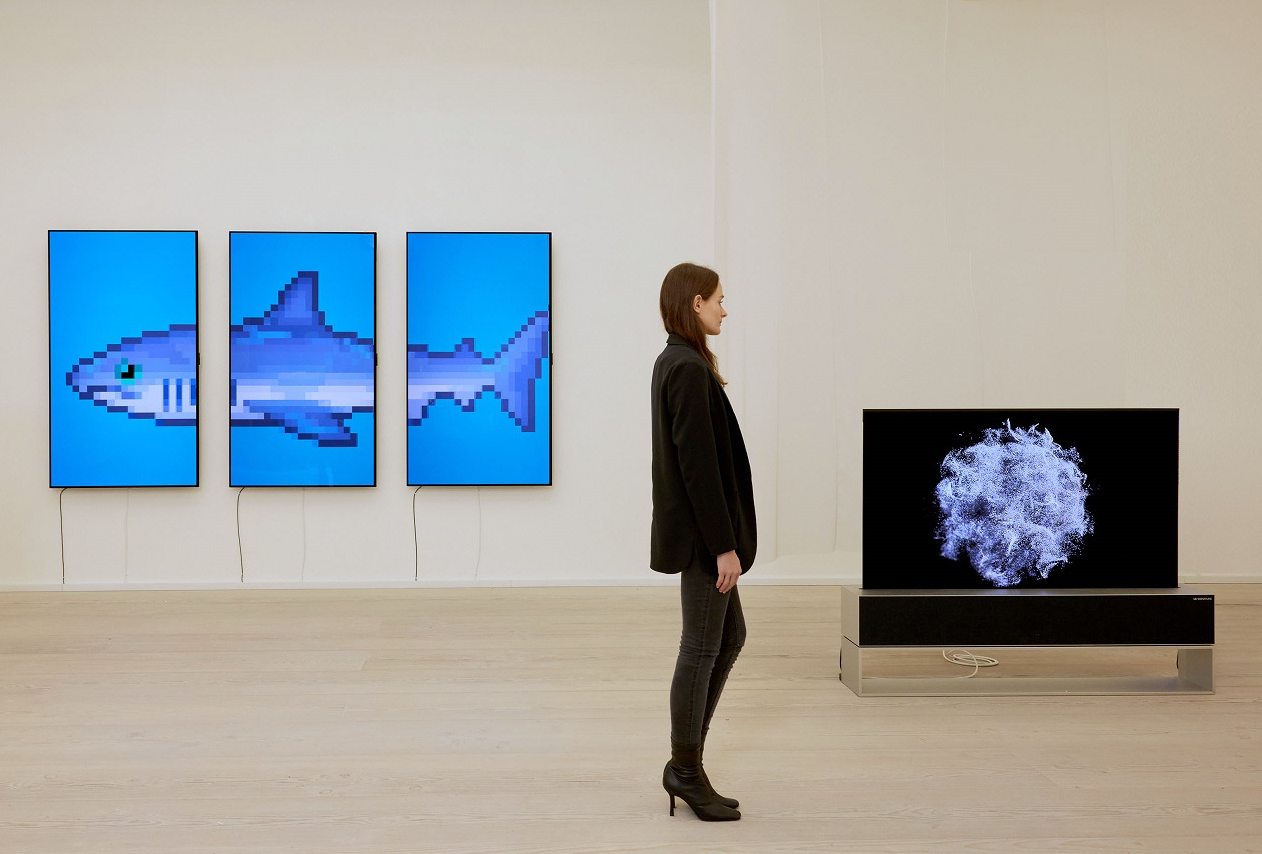 From left, 'THE S/H/A/R/K' by Damien Hirst and 'The Moment & Morpho Luna' by Je Baak displayed on LG OLED TVs at Saatchi Gallery