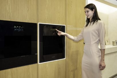 A photo of a woman experiencing a built-in oven in the SIGNATURE KITCHEN SUITE Kitchen zone at Salone del Mobile