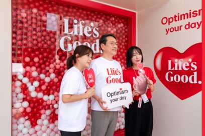 A picture LG CEO William Cho and two women posing with different postcards and slogans