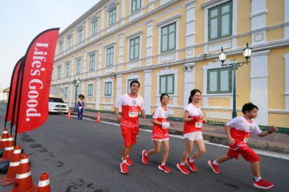 A photo of four smiling people running in a 10K race