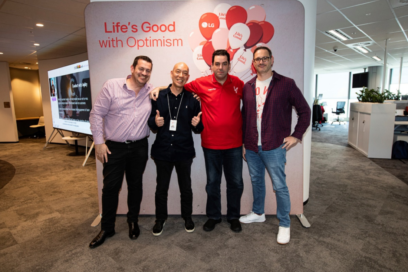 A picture of four LG employees posing infront of a logo banner