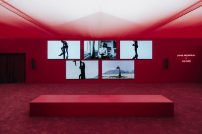 The exhibition space features an artistic collaboration between John Akomfrah and LG OLED, with a designated seating area for visitors