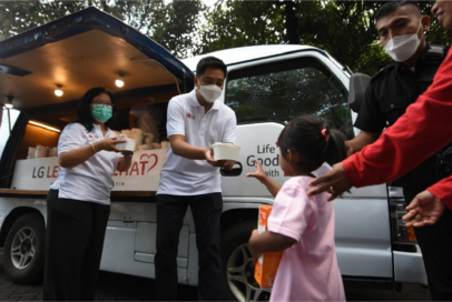 A photo of a kid receiving meals from a mobile lunch truck with the LG Electronics logo