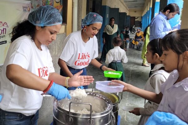 A photo of local children in India receiving rice in a lunchbox